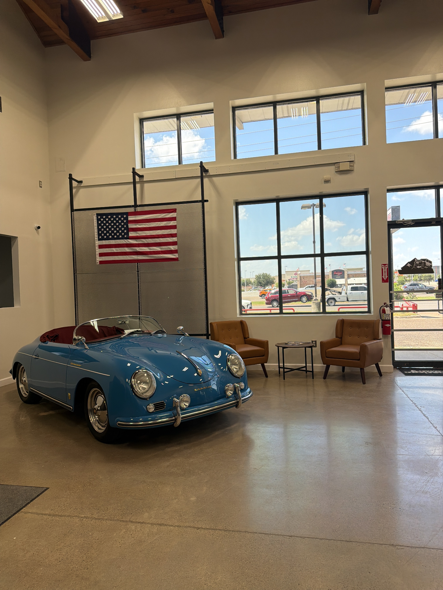 RGV Off-Road McAllen showroom interior with vintage Porsche 356 Speedster display, high wood-beam ceilings and lounge seating